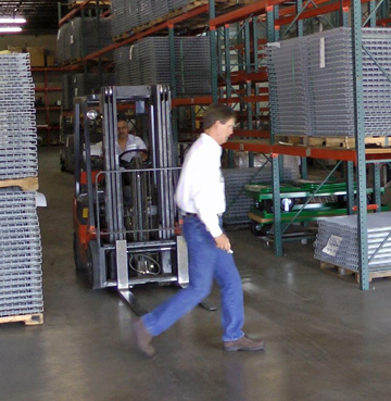 man walking in a forklift aisle