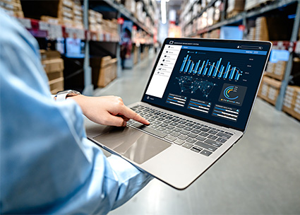 man using laptop in a warehouse