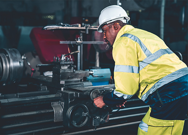 worker wearing safety gear using machine