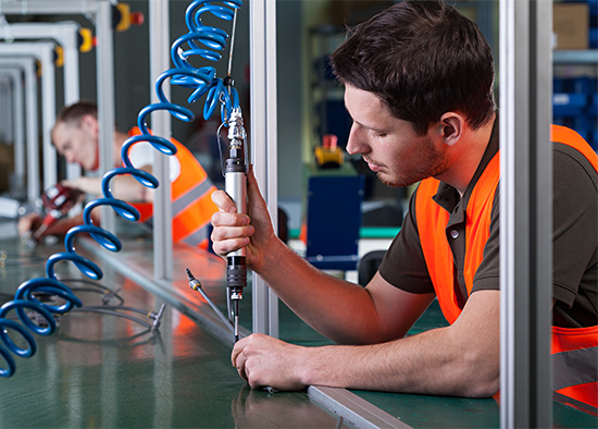 worker using powered tool in assembly line