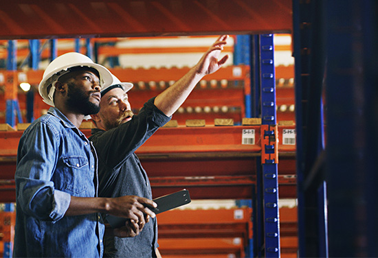 workers inspecting pallet rack aisle