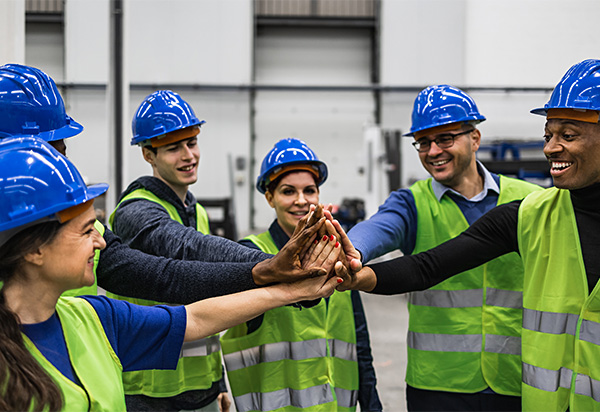 warehouse team in hardhats in a huddle
