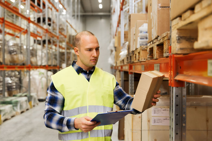 warehouse worker in a pallet rack aisle