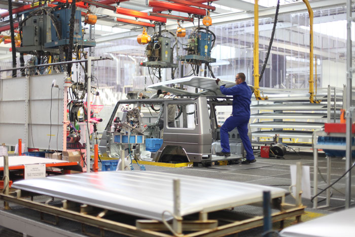 worker at a manufacturing plant using a hoist