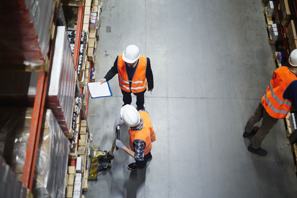 men working in a warehouse rack aisle