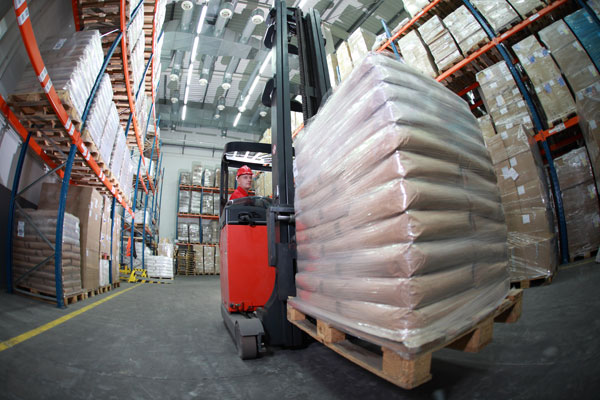 forklift carrying a heavy loaded pallet in a warehouse