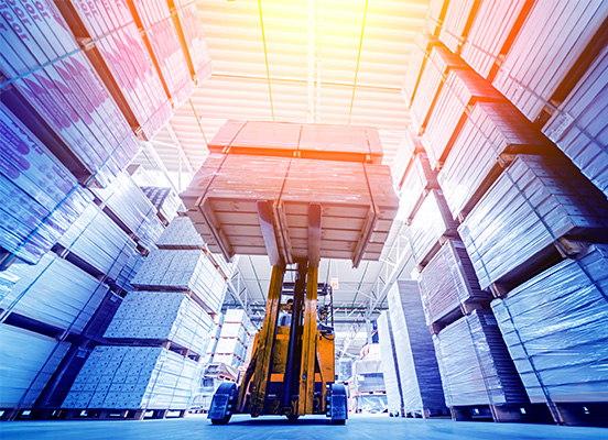 forklift carrying palletized load in tall warehouse