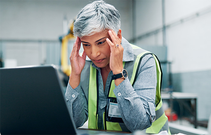 warehouse professional looking at computer and holding temples