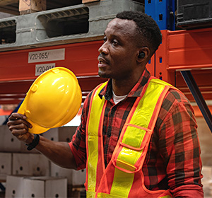 worker fanning himself with hard hat
