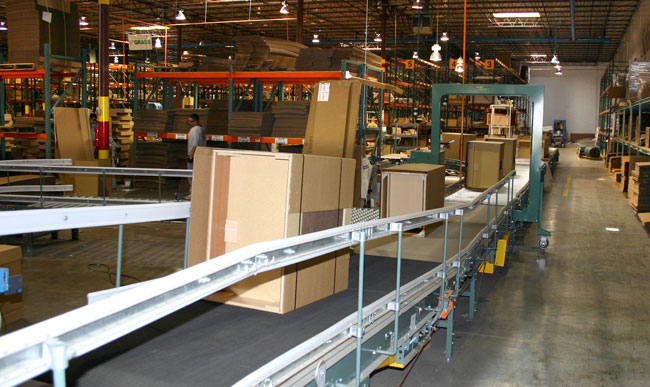 Warehouse conveyor system with guardrails on the side to prevent products from falling.