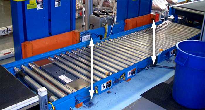 In-line lift along a conveyor line lowers and raises loads in mid-transport.