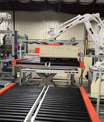 scissor lift at the end of conveyor line, integrated with robotic palletizer.