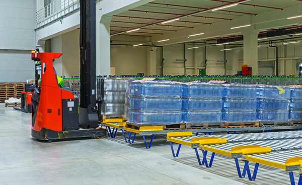 gravity conveyor carrying pallets to a manufacturing process.