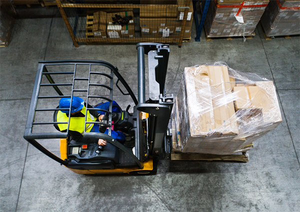 Forklift driver as seen from overhead in a warehouse. Forklift is in motion.