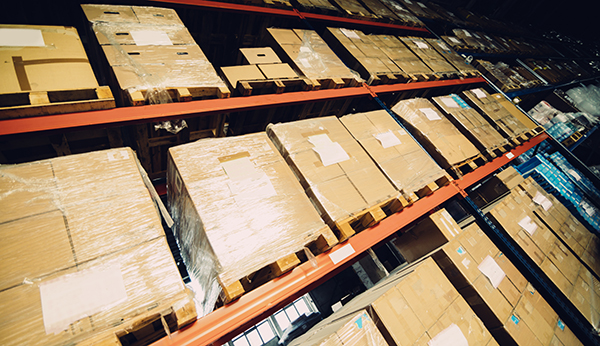 A row of heavily loaded pallet rack in an industrial warehouse.