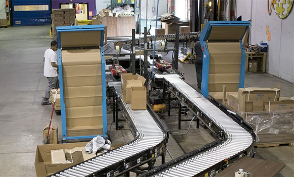 conveyor line feeds automated packaging in a distribution center.