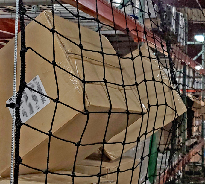 Pallet rack safety net catches cartons to prevent falling items from landing below.