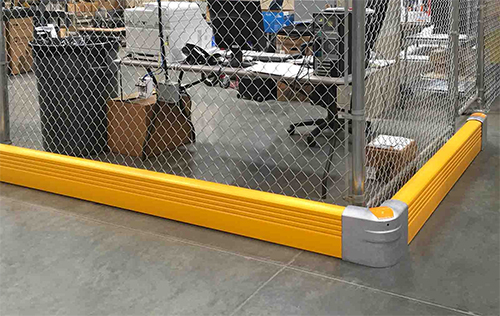 Floor level flexible guardrail protects a work area in a warehouse.
