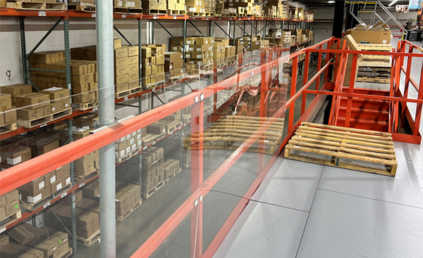 Mezzanine and pick module safety railing with clear barrier to protect against falling items and enhance personnel fall protection.