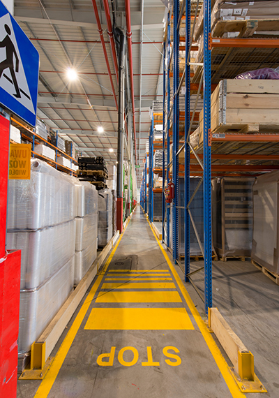 narrow pedestrian aisles at the end of a series of pallet rack rows.