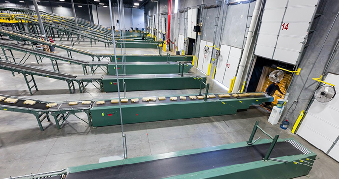 Extendable conveyors feed truck loading docks at a distribution center.