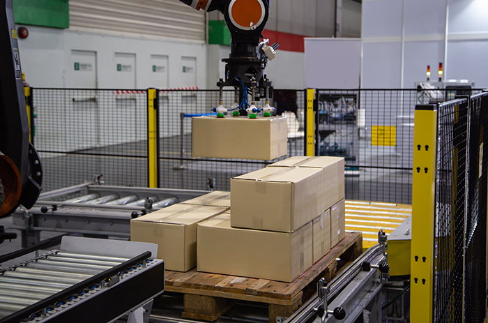 robotic palletizer surrounded by wire machine guarding.