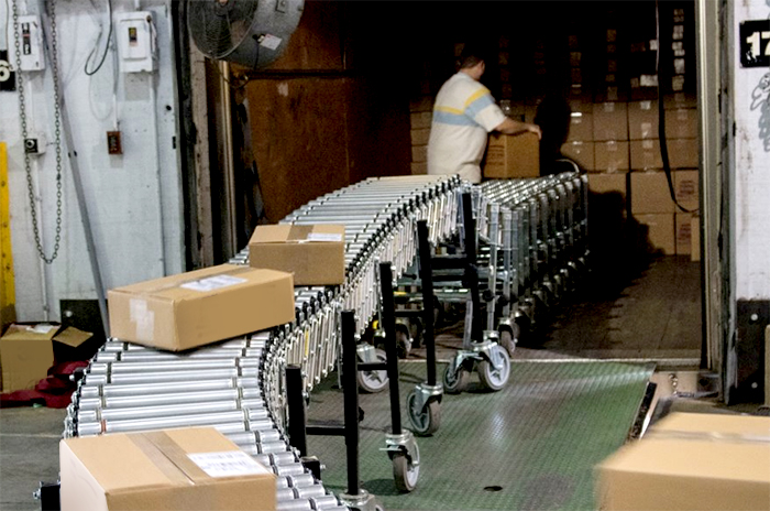 flexible conveyor extended into a tractor trailer for loading at a distribution center.