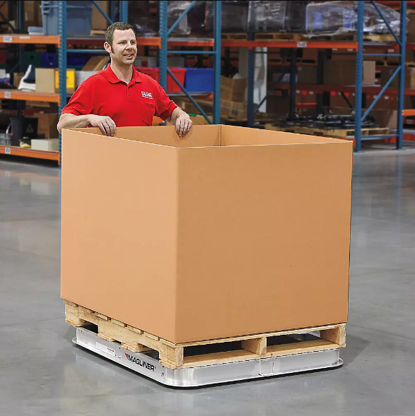 Worker using pallet dolly in warehouse