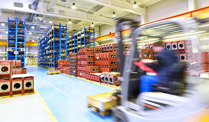 Forklift driving fast in a production facility.