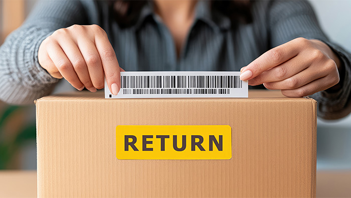 woman placing barcode on box marked "return"