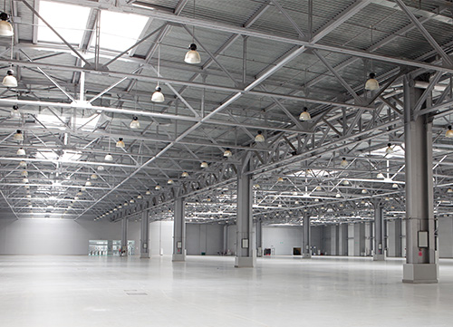 empty warehouse with support columns, girders and lights