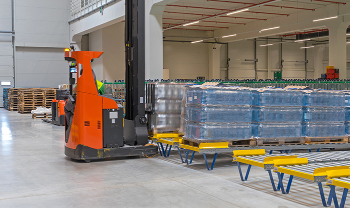 forklift unloading pallets from the end of conveyor line
