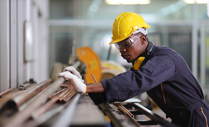 manufacturing worker with tube sawing process.