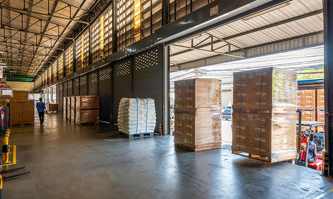 Receiving dock with staged shipments and open dock doors in a warehouse.